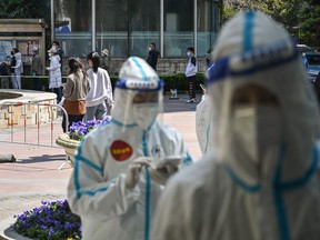 Residents wait in a line to be tested for the COVID-19 coronavirus during the second stage of a pandemic lockdown in Jing' an district in Shanghai on April 4, 2022.