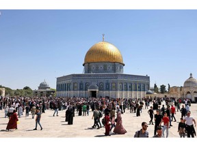 Palestinian Muslims gather at Jerusalem's Al-Aqsa mosque complex following Friday prayers during the holy month of Ramadan on April 15, 2022.