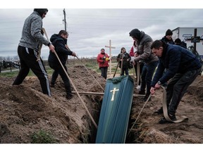 Family members bury a man who was shot dead on his bicycle in Bucha, Ukraine, on April 19, 2022, during the Russian invasion.