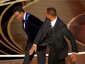 FILE PHOTO: Will Smith (R) hits Chris Rock as Rock spoke on stage during the 94th Academy Awards in Hollywood, Los Angeles, California, U.S., March 27, 2022.