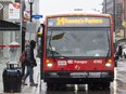 A passenger embarks on an OC Transpo city bus at the corner of Gladstone and Elgin Street.