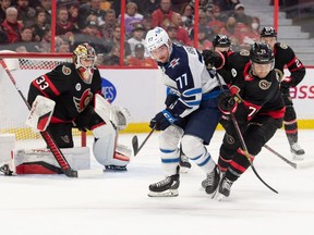 Winnipeg Jets centre Adam Brooks (77) battles with Ottawa Senators centre Chris Tierney (71) in the first period at the Canadian Tire Centre.