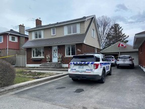 Ottawa Police Service vehicles sit parked outside a taped-off house on Smyth Road, where police investigating what they described as the homicide of an elderly man on Friday.