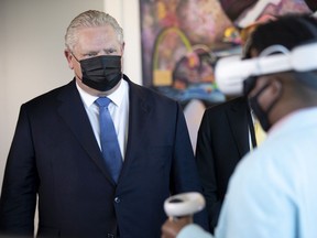 Ontario Premier Doug Ford watches as a Meta employee demonstrates VR technology at the company's offices in Toronto earlier this week. His government has tried to keep the province open for business, even as experts say a sixth wave  of COVID is underway.