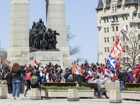 Un grand groupe de manifestants se rassemblent au Monument commémoratif de guerre du Canada samedi après-midi après le passage du défilé de motos «Rolling Thunder Ottawa» sur la rue Elgin.