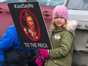 A child holds a sign during a protest in Trenton, Ontario in early February denouncing Bill Gates, who has been accused by conspiracy theorists of perpetrating COVID-19.