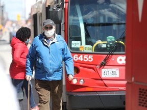 OC Transpo users, masked and unmasked, on Rideau Street in Ottawa.