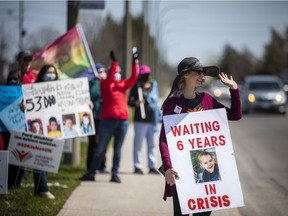 Cathy Varrette and other parents of autism families demonstrate Saturday outside the campaign launch of Conservative incumbent Jeremy Roberts in Ottawa West-Nepean.