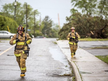 The Stittsville area and many other parts of the Ottawa region were hit by a powerful storm on Saturday, May 21, 2022.  Firefighters run up Carleton Cathcart Street.