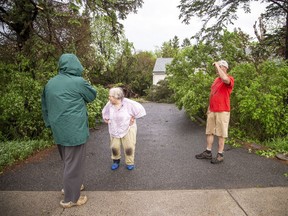 The Stittsville area and many other parts of the Ottawa region were hit by a powerful storm on Saturday, May 21, 2022. A woman assesses the damage in her front yard at a home on Stittsville Main Street.