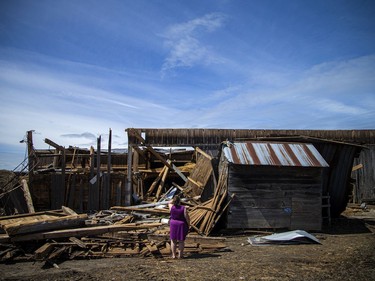 Brianna LaRose looks out at the damage to the historic barn her family has had for centuries in White Lake, Monday, May 23, 2022.