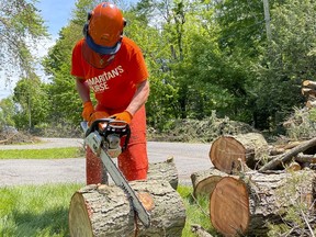 Scott Armstrong, from Hanover, Ont., cleans up a storm damaged property in the Pine Glen area on Monday as part of his volunteer work with disaster relief organization Samaritan's Purse.