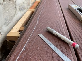 This composite deck board is marked for cutting so it will fit well against the irregular stone of this house. This particular project involved resurfacing and existing deck frame with composite.