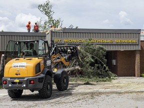 A crew cleans up damage from the weekend storm at St. Monica Catholic School. Tuesday, May. 24, 2022.