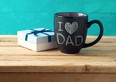 Happy Father's day concept with coffee mug and gift box over wooden background