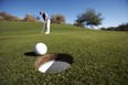 Male golfer putting on golf course