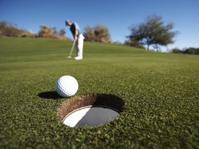 Male golfer putting on golf course