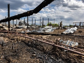 A Ukrainian soldier walks through the grounds of a lumber mill which was rocketed by Russian forces on May 17, 2022 in Zolochiv, Ukraine.