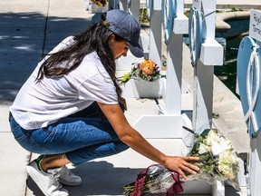 Meghan Markle, the wife of Britain's Prince Harry, places flowers as she mourns at a makeshift memorial outside Uvalde County Courthouse in Uvalde, Texas, on May 26.