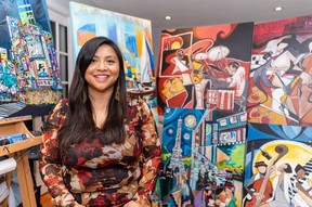 Nguyen is posing for a photo in front of some of her paintings. Thomas Desormeaux / Postmedia