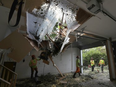 OTTAWA - May 23 2022 -  Hundreds of families from Navan were out clearing trees from their properties Monday after a storm ripped through the Ottawa area Saturday. A crew from D&D Tree Service clears a tree off a roof Sunday afternoon.   TONY CALDWELL, Postmedia.