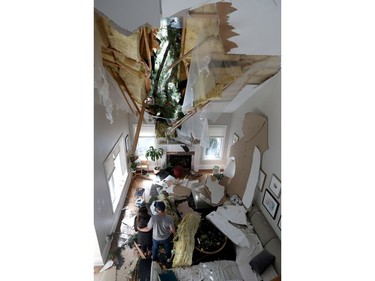 OTTAWA - May 23 2022 -  Hundreds of families from Navan were out clearing trees from their properties Monday after a storm ripped through the Ottawa area Saturday. Courtney Cameron and Nick Workman stand in their living room and look at the damage a tree caused after Saturday's storm.   TONY CALDWELL, Postmedia.