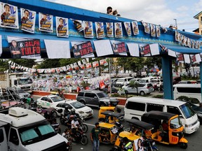 People ride during a traffic jam near polling precincts as Filipinos vote during the national elections in Quezon City, Philippines, May 9, 2022.