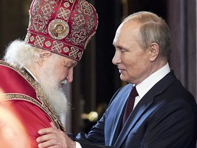 Russian Orthodox Church Patriarch Kirill, left, and Russian President Vladimir Putin greet each other after the Easter service at the Christ the Saviour Cathedral in Moscow, April 24.