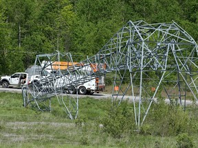 A massive hydro tower lies crumpled in half along Highway 417 near Hunt Club Road as crews continue to try to restore power on Monday.