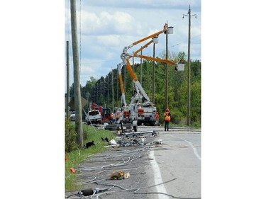 Crews work to restore power at downed hydro poles along Hawthorne Avenue, which remained closed to traffic near Hunt Club Road Monday.