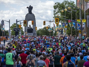 A wave of runners make their way up the hill northbound on Elgin Street, toward the National War Memorial, during their 5K race on Saturday.