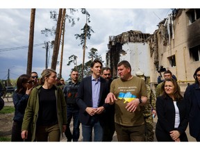 Prime Minister Justin Trudeau, Deputy Prime Minister Chrystia Freeland (at right of frame) and Foreign Affairs Minister Melanie Joly  (at left of frame) walk with Irpin Mayor Oleksandr Markushyn through the destroyed neighborhood in Irpin, Ukraine May 8, 2022.