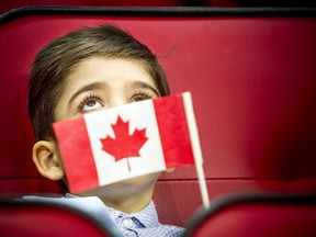 In 2020, Immigration, Refugees and Citizenship Canada (IRCC) partnered with the Ottawa Senators in a special citizenship ceremony, where 20 families from 20 countries became Canadian citizens. Here, seven-year-old Karam Alokel holds his flag during the ceremony.