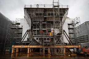 A worker stands on a Joint Support Ship being built for the Royal Canadian Navy at Seaspan Shipyards in North Vancouver, B.C., in October 2020.