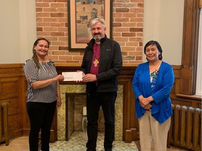 Bishop Shane Parker and Deborah Tagornak present a cheque for the proceeds of this year's Bishop's Gala to Stephanie Mikki Adams of the Inuuqatigiit Centre.