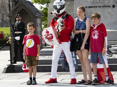 A protestor poses for photos with children in front of the Tomb of the Unknown Soldier at the National War Memorial on Thursday, Jun. 30, 2022.