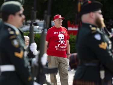 A protestor watches the changing of the guard at the Tomb of the Unknown Soldier at the National War Memorial on Thursday, Jun. 30, 2022.