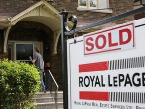 A realtor's sign stands outside a house that had been sold in Toronto.