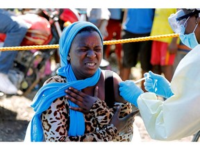 A young woman reacts as a health worker injects her with the Ebola vaccine, in Goma, Democratic Republic of Congo. We've learned many lessons about the spread of disease; now we need to strengthen our preventive measures globally.