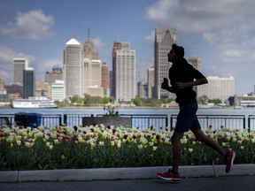 The silhouette of a runner is silhouetted against the Detroit skyline.  America still has a heart.