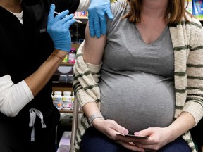 FILE PHOTO: A pregnant woman receives a vaccine for the coronavirus disease (COVID-19) at Skippack Pharmacy in Schwenksville, Pennsylvania, U.S., February 11, 2021.
