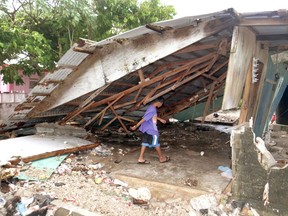 A boy walks under a damaged house in the Marshall Islands after storm surges caused widespread flooding. Climate change is a major concern for Pacific island states such as the Marshals, Kiribati and Tuvalu.