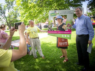 Mayor Jim Watson posed for a photo with Barbara Sibbald, the organizer of Saturday's Celebrate Gardening! event at Dundonald Park as well as lead gardener with the Centretown Community Association, and Michel Gauthier, president of Gardens Ottawa.