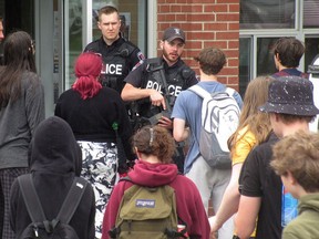 Kingston Police check the identity of students and staff returning to Frontenac Secondary School after the school was locked down on Thursday.