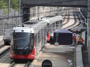 Crews work on an LRT car that derailed at Tunney's Pasture Station in August 2021.
