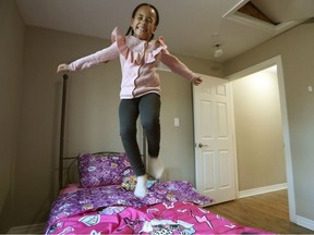 Sabrina Hokcha Djiele jumps on her new bed at her new Ottawa apartment after arriving from Ukraine on Monday.