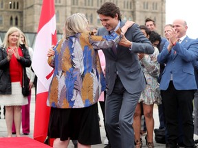 Along with other politicians and dignitaries, Prime Minister Justin Trudeau was on hand for the raising of the Pride flag on Parliament Hill Wednesday.
Here, he helps former Green Party leader Elizabeth May down from the podium, where she also delivered remarks.