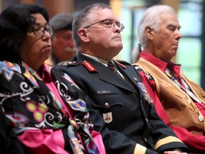 Der Kommandeur der kanadischen Armee und Verteidigungsteam-Champion für indigene Völker, Generalleutnant Jocelyn Paul (Mitte), hatte die Ehre, die Symbole während der Zeremonie zu enthüllen.