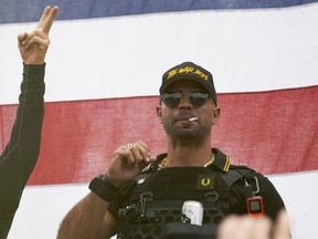 FILE - Proud Boys leader Enrique Tarrio wears a hat that says The War Boys and smokes a cigarette at a rally in Delta Park on Sept. 26, 2020, in Portland, Ore. Tarrio, the former top leader of the far-right Proud Boys extremist group, and other members were indicted Monday, June 6, 2022, on seditious conspiracy charges for what federal prosecutors say was a coordinated attack on the U.S. Capitol to stop Congress from certifying President Joe Biden's 2020 electoral victory.
