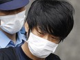 Tetsuya Yamagami, suspected of killing former Japanese premier Shinzo Abe, is escorted by a police officer as he is taken to prosecutors, at Nara-nishi police station in Nara, western Japan, in this photo taken by Kyodo July 10, 2022. Kyodo via REUTERS.